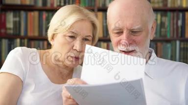 老年夫妇阅读投资理财文件.. 有税务报告的退休养恤金领取者家庭